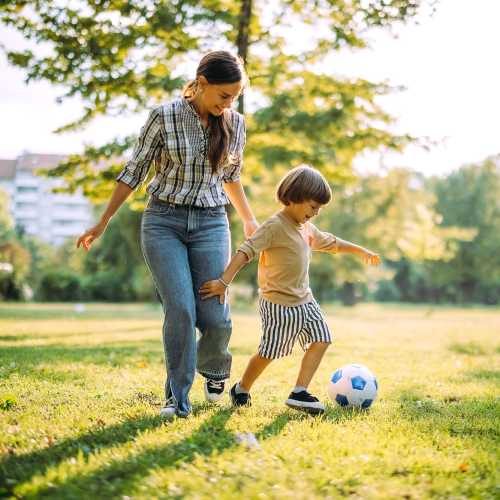 Resident woman playing football with her son at Oak Hill in Escondido, California