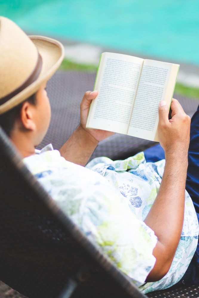 Resident reading by the pool at Lakewood Park Apartments in Lexington, Kentucky