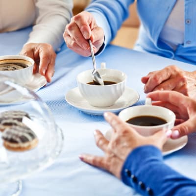 Table top with residents stirring their coffee at Vintage Hills of Indianola in Indianola, Iowa