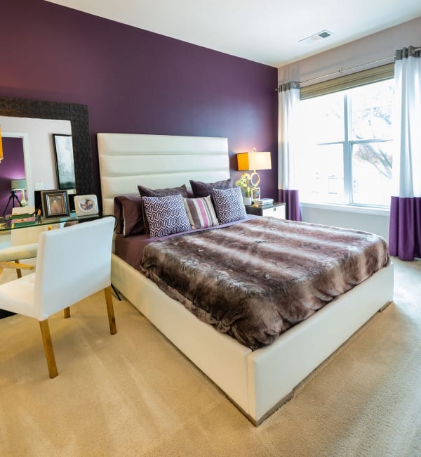 An apartment bedroom with a sliding glass door to outside at Residences at Congressional Village in Rockville, Maryland