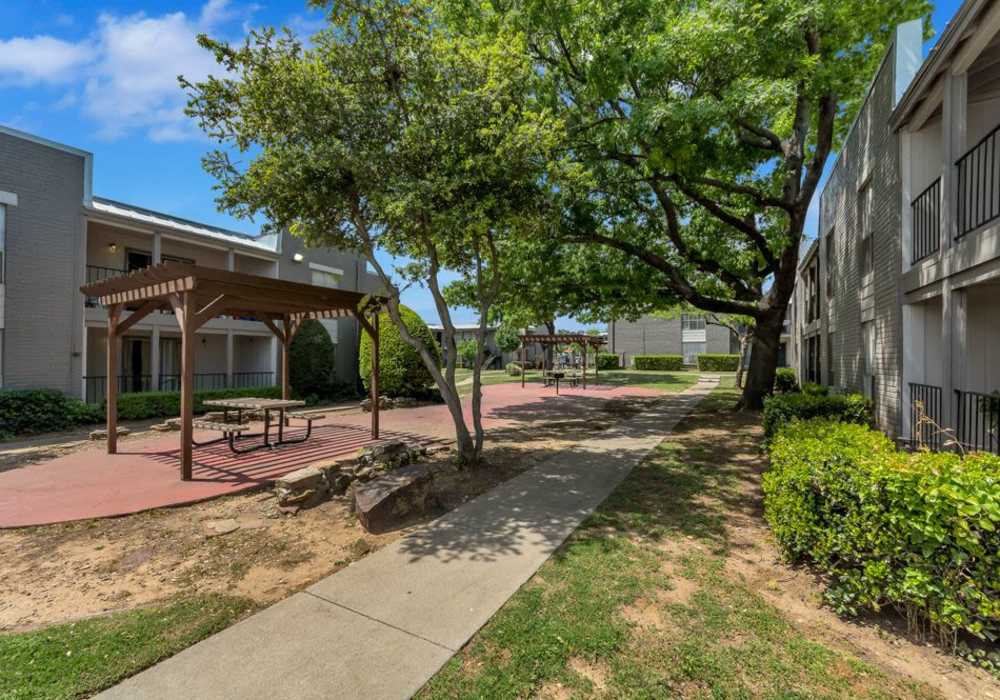 Community exterior with cabana seating at Mission Pointe Club Apartments in Euless, Texas