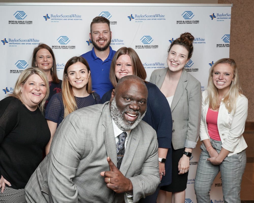 Employees posing for a photo at a charity event near Olympus Property in Fort Worth, Texas