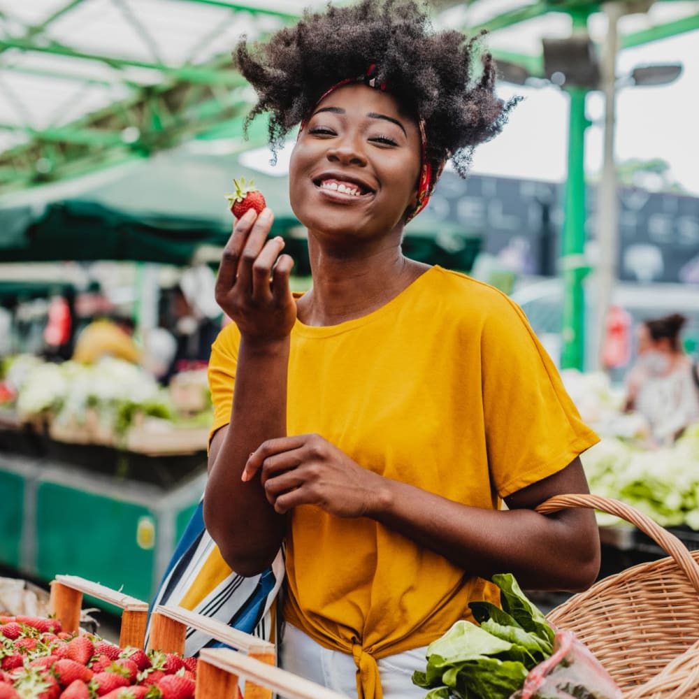 Woman tasting some delicious fruit at the local market near Dakota Mill Creek in Buford, Georgia