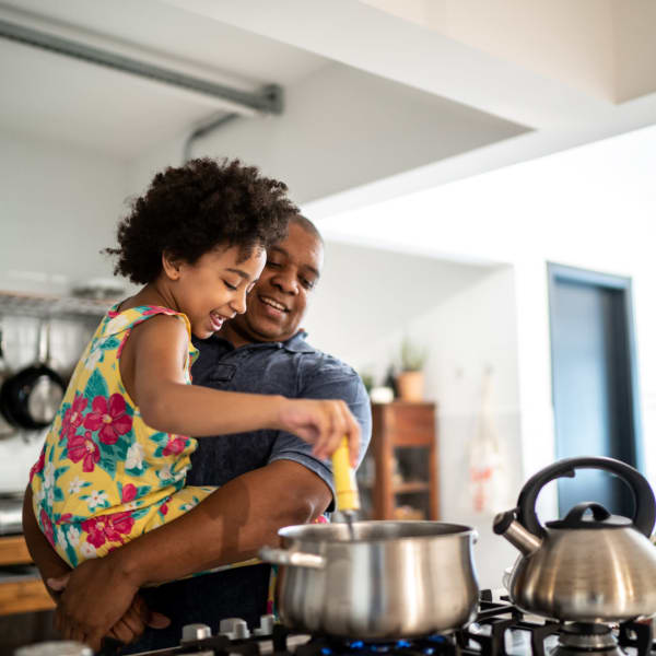 A man and his daughter cooking up a meal at their Sandpiper Apartments apartment in Seatac, Washington