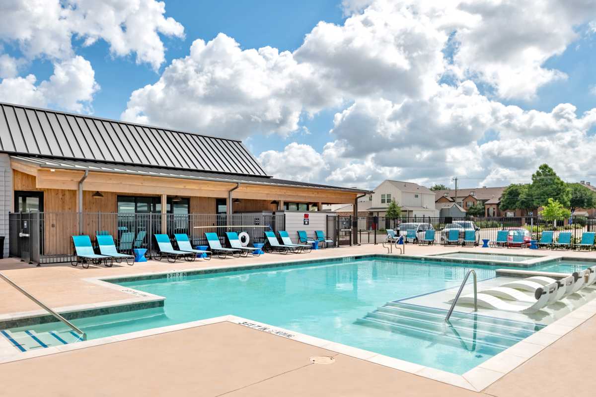 Beautiful swimming pool surrounded by lounge chairs at Elevate at Skyline in McKinney, Texas