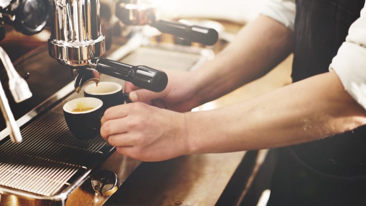 A barista works the espresso machine