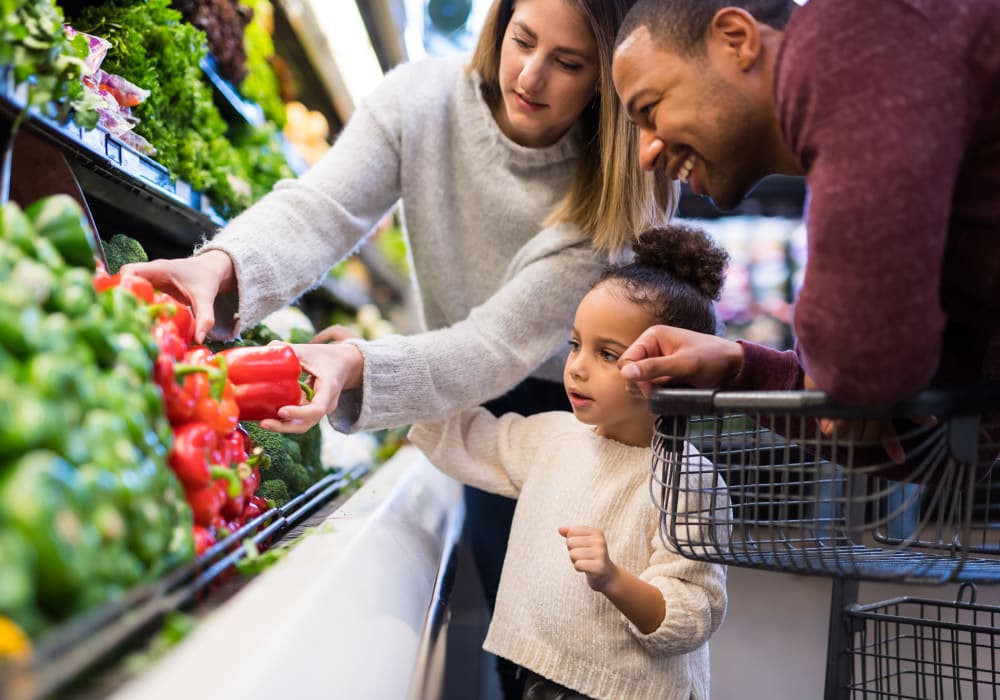 Family shopping for bell peppers at a grocery store in Dallas, Texas near Oaks White Rock