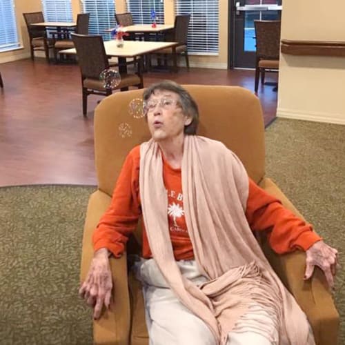 Resident blowing bubbles at Oxford Glen Memory Care at Grand Prairie in Grand Prairie, Texas