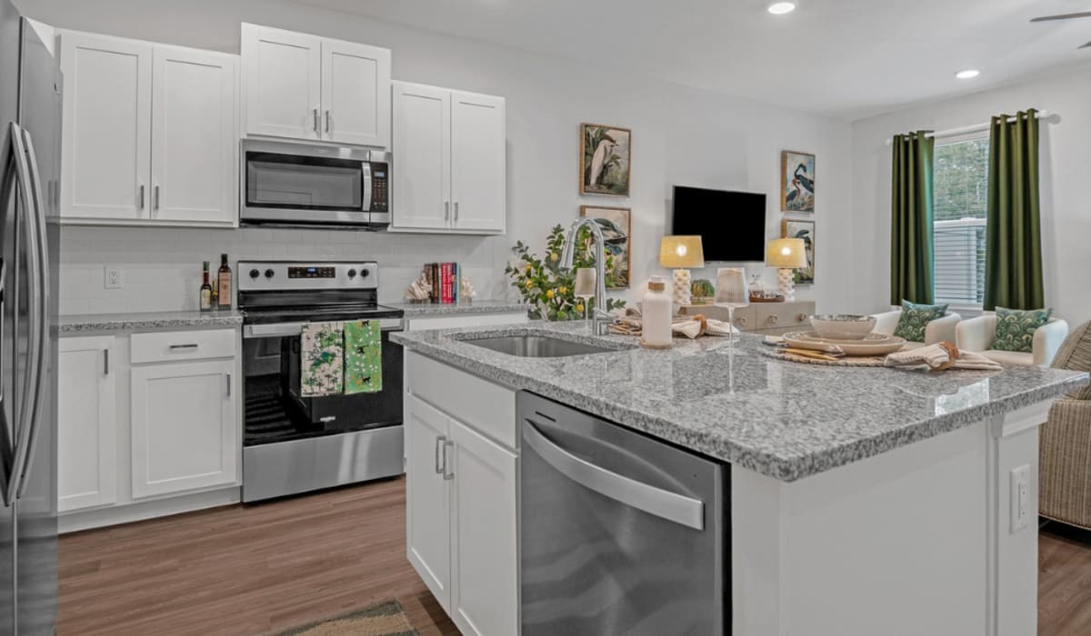 A model apartment kitchen with an island at Artisan Living North Beach in Santa Rosa Beach, Florida
