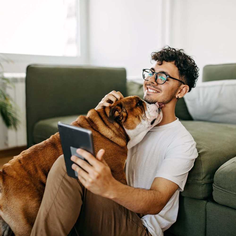 Resident with his dog in a living room at The Meadows on Blue Bell in Houston,Texas