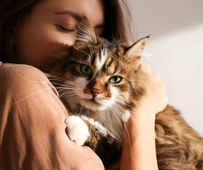 Resident hugging her cat in their new home at Rivers Pointe Apartments in Liverpool, New York