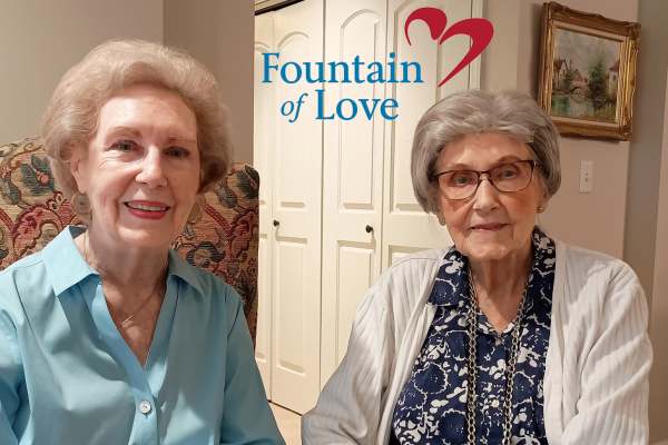 Two female residents with the Fountain of Love logo