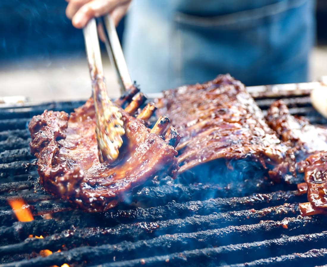 Man grilling meat at BBQ outdoor at DaVinci Apartments in Davis, California