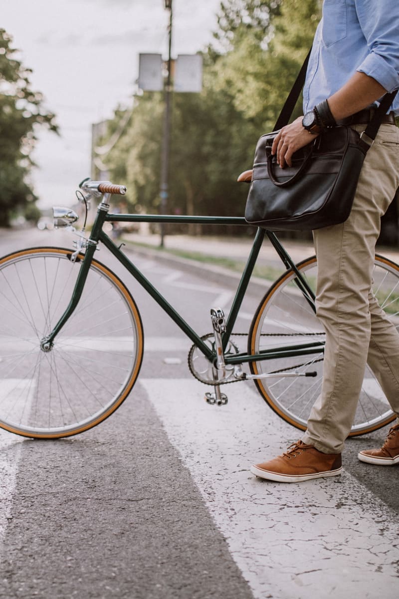 Resident crossing a crosswalk with his bike on his way to work near 933 The U in Rochester, New York