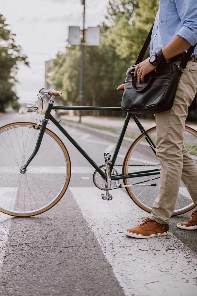 Resident crossing a crosswalk with his bike on his way to work near Arden at South Point Apartment Homes in McDonough, Georgia