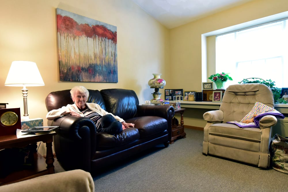 Resident relaxing in her living room in senior living apartment at Garden Place Millstadt in Millstadt, Illinois