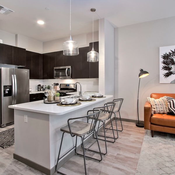 Gourmet kitchen with stainless-steel energy star appliances and quartz countertops in a model apartment at Jade Apartments in Las Vegas, Nevada