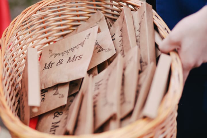 wedding favors brown envelopes with mr. and mrs. on them in a wicker basket