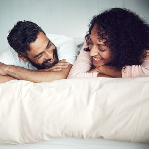 A happy couple lying down on the bed at Chollas Heights Historical in San Diego, California