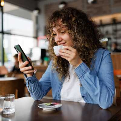 Woman having coffee at a cafe nearby The Gardens, Houston, Texas