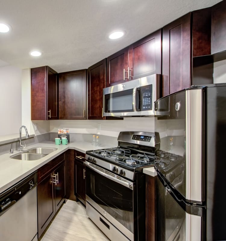 Modern kitchen with sleek, stainless-steel appliances and a gas range in a model home at Sofi at 3rd in Long Beach, California