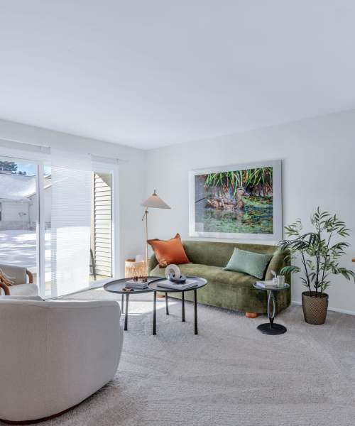 Model living room with a stylish yellow sofa at Muirwood in Farmington Hills, Michigan