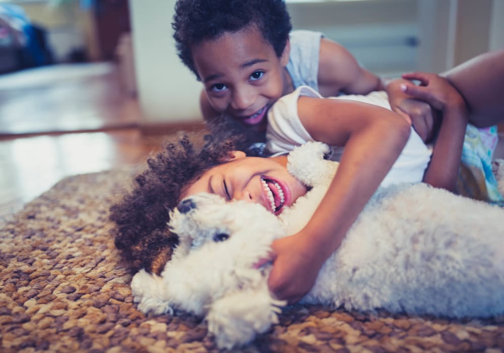 Resident children and their puppy loving their new home at another community by at Olympus Property in Fort Worth, Texas