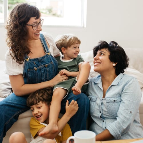 a resident family smiling and laughing together at Coral Sea Cove in Port Hueneme, California