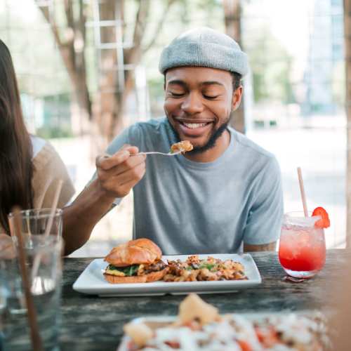 Man enjoying meal at outdoor dining table Bayview Student Living in North Miami, Florida 