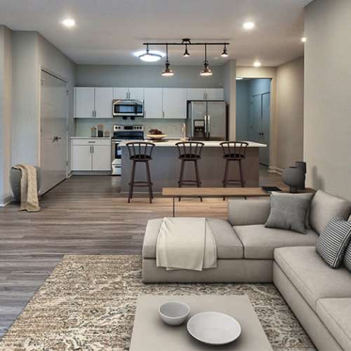 Open concept model living room and kitchen with faux wood flooring at Buckstone Flats in Lockbourne, Ohio