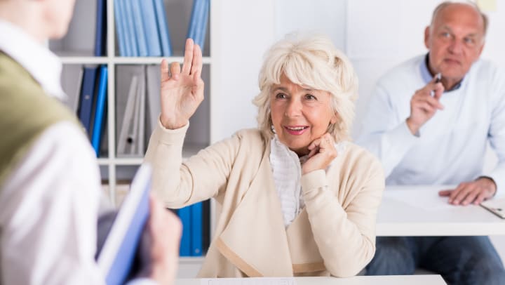 Elderly woman raising her hand