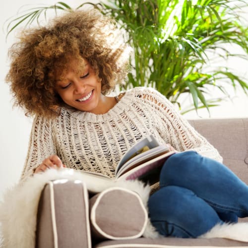 A resident sitting on a couch reading at Lovell Cove in Patuxent River, Maryland