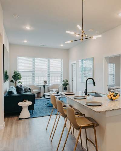 Open layout living room and kitchen with an island at Arden at Midtown GP in Grand Prairie, Texas