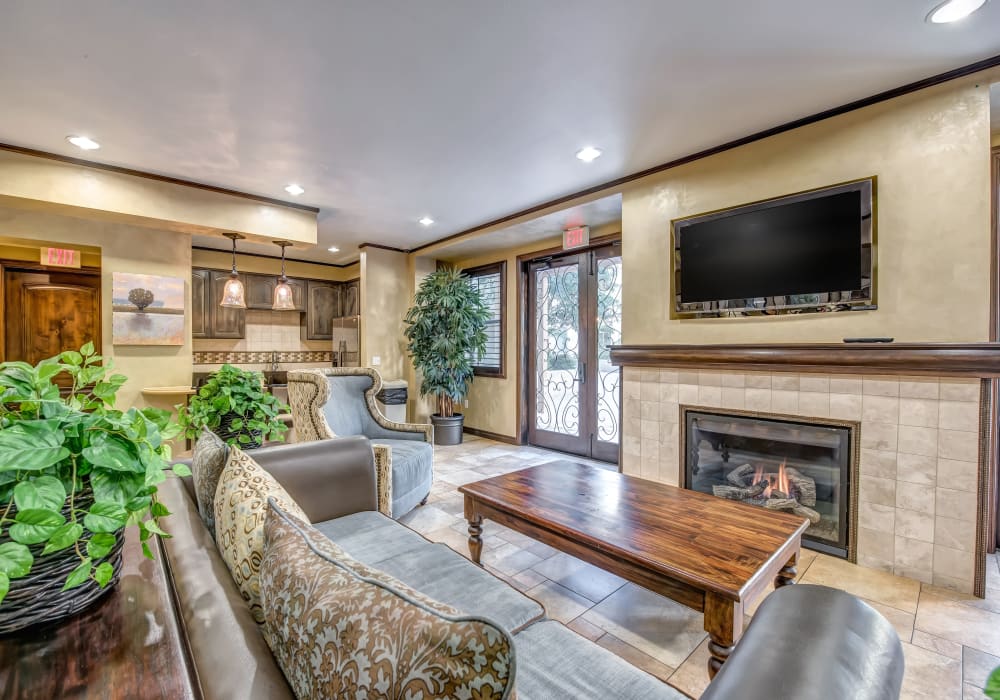 Beautifully decorated resident clubhouse interior with tiled flooring and a fireplace at Sofi at Topanga Canyon in Chatsworth, California