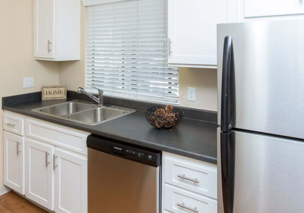 Fully-equipped kitchen with sink and refrigerator at Amber Court in Fremont, California,