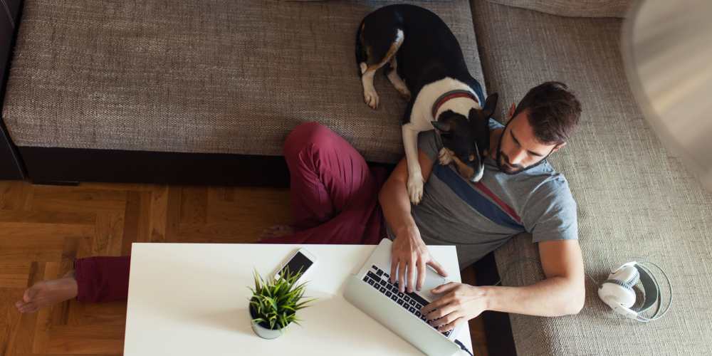 Man working on his laptop with his dog at The Meridian Apartment Homes in Walnut Creek, California