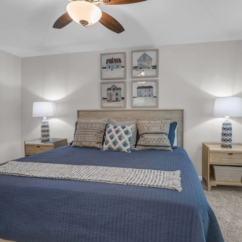 A king sized bed with side tables and lamps on either side in a model bedroom at Artisan Living North Beach in Santa Rosa Beach, Florida