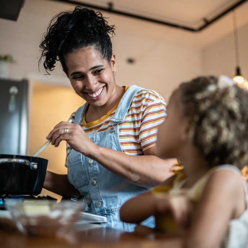 Resident cooking a delicious meal in the well-equipped kitchen of his apartment at Del Prado at Texas Star in Euless, Texas
