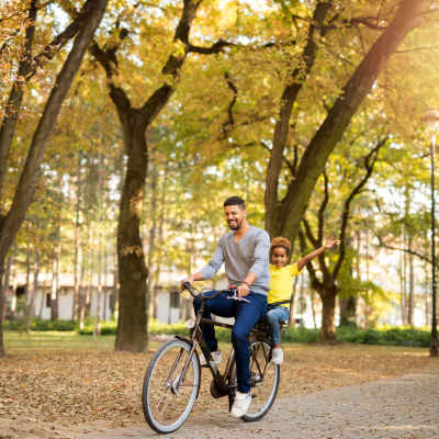 Father with his child riding a bicycle near Towne Creek Apartment Homes, Gainesville, Georgia