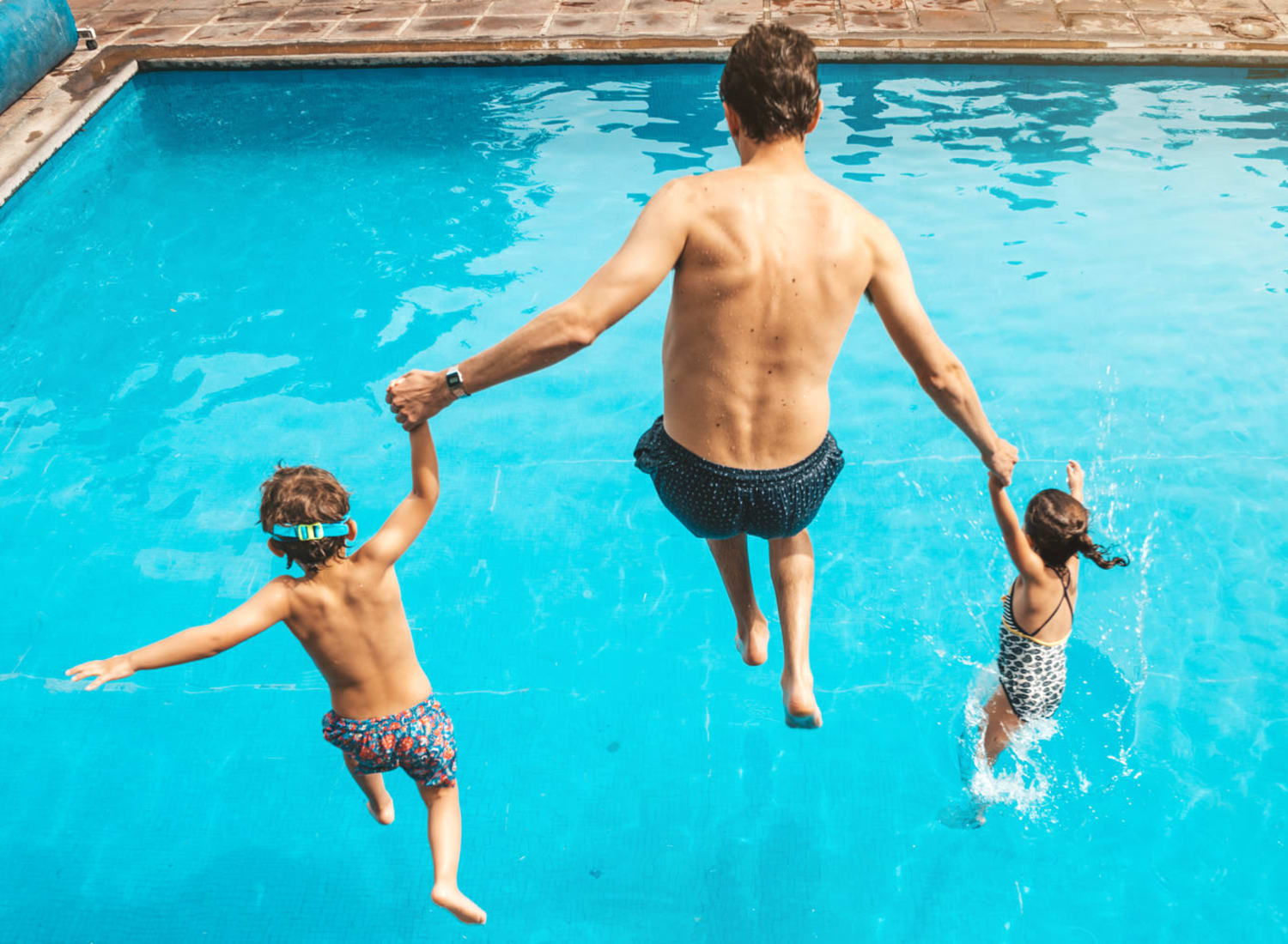 Dad and kids jumping into the pool at The Reserve at White Oak in Garner, North Carolina