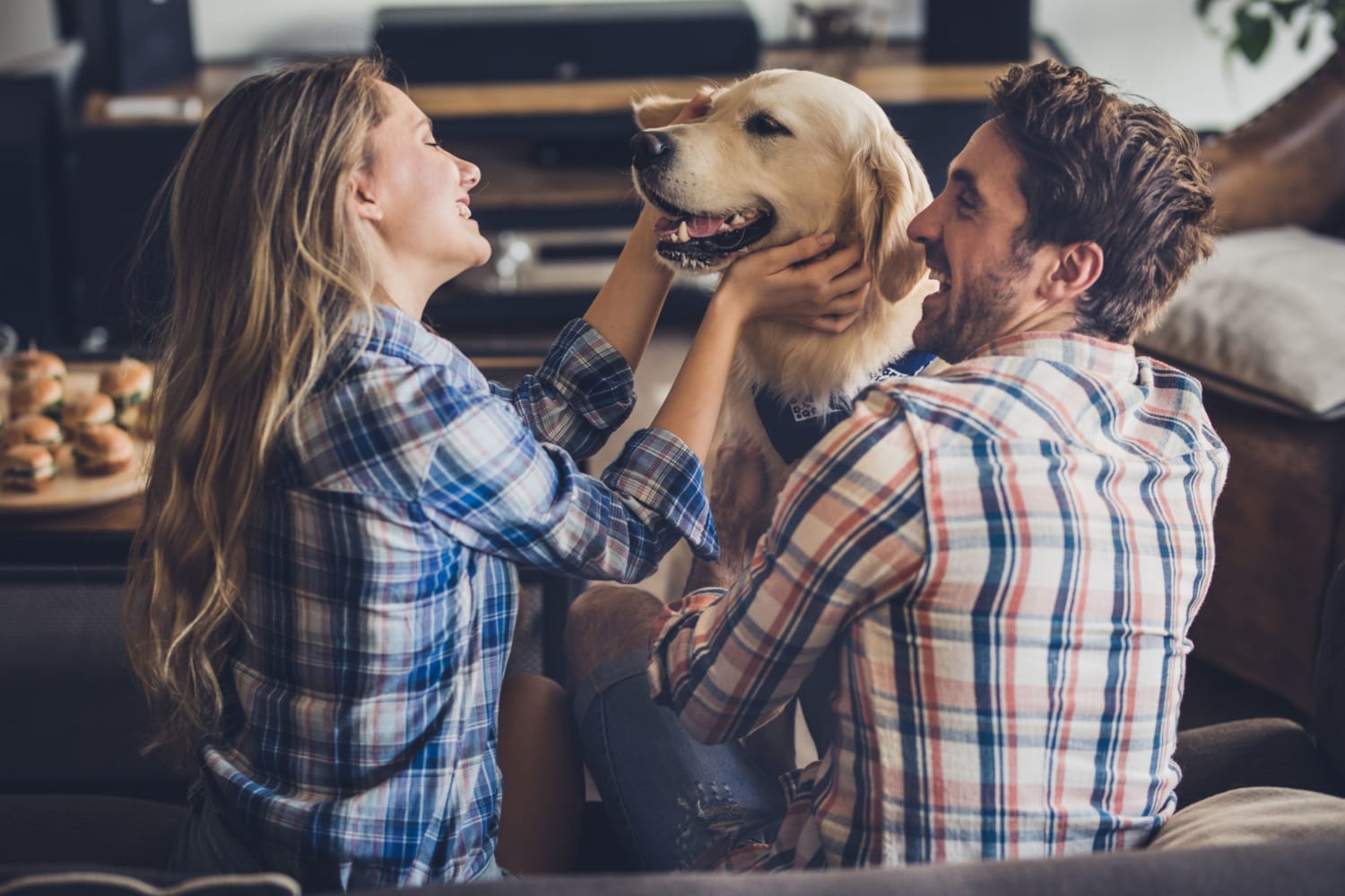 Resident couple plays with a dog in their new apartment at Hunters Point in Zionsville, Indiana