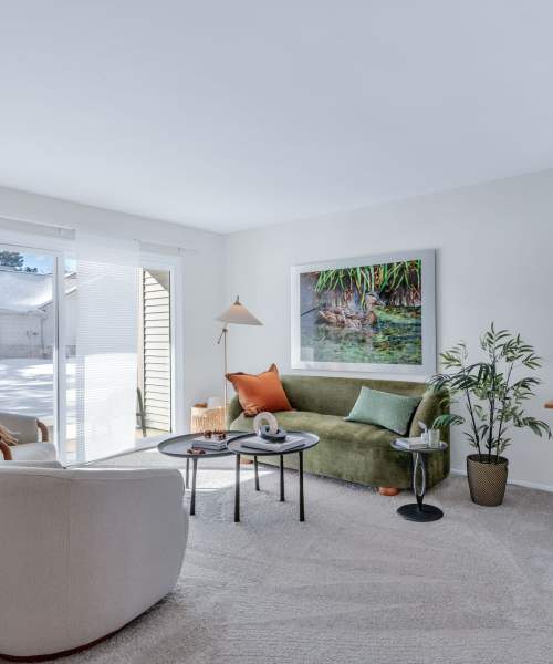 Model living room with a stylish yellow sofa at Muirwood in Farmington Hills, Michigan