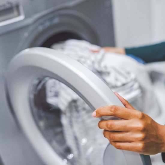 Resident putting her cloth in washer at Nexus 485 in Charlotte, North Carolina