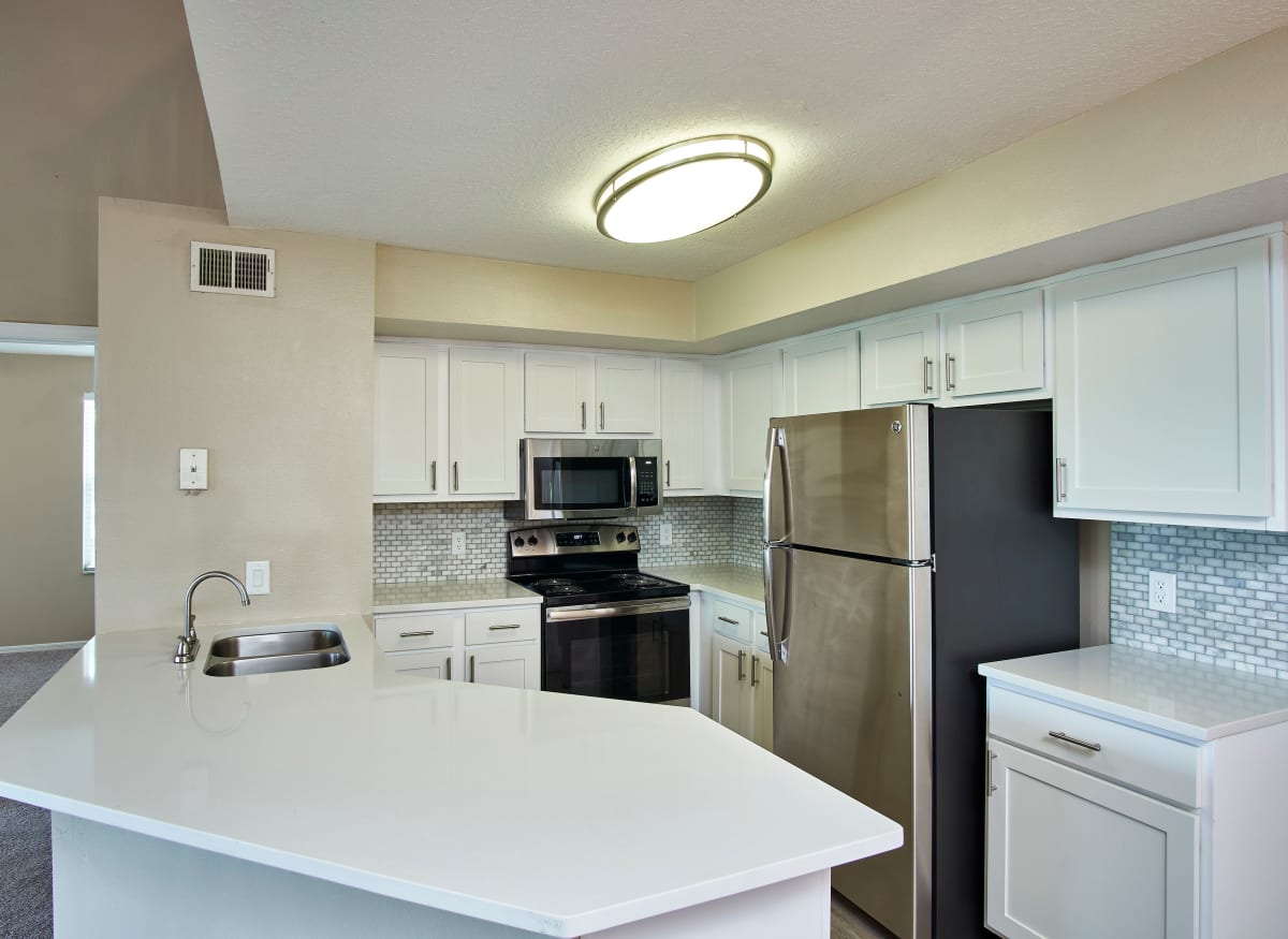 A large kitchen with white cabinets at Calais Park Apartments in St Petersburg, Florida