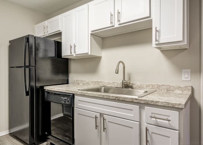 Modern kitchen with hardwood floors in model home at The Arbors of Carrollton in Carrollton, Texas