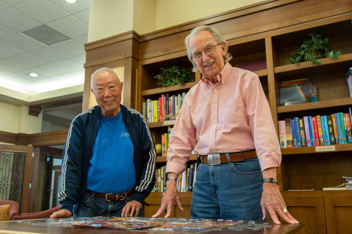 Two residents put the finishing touches on a puzzle.