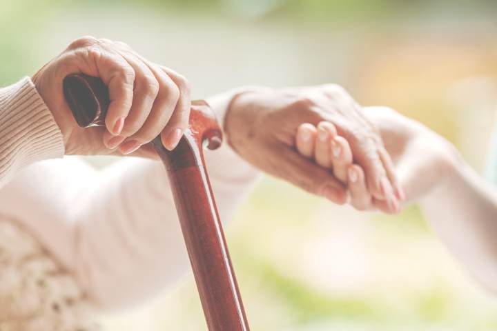 Close-up of caregiver holding a senior’s hand at The Landing at Stone Oak in San Antonio, TX, symbolizing trust, support, and compassionate senior care.