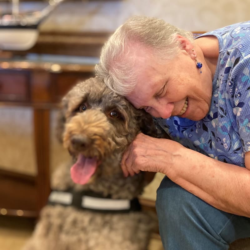 Resident petting a visiting dog at The Clinton Presbyterian Community in Clinton, South Carolina