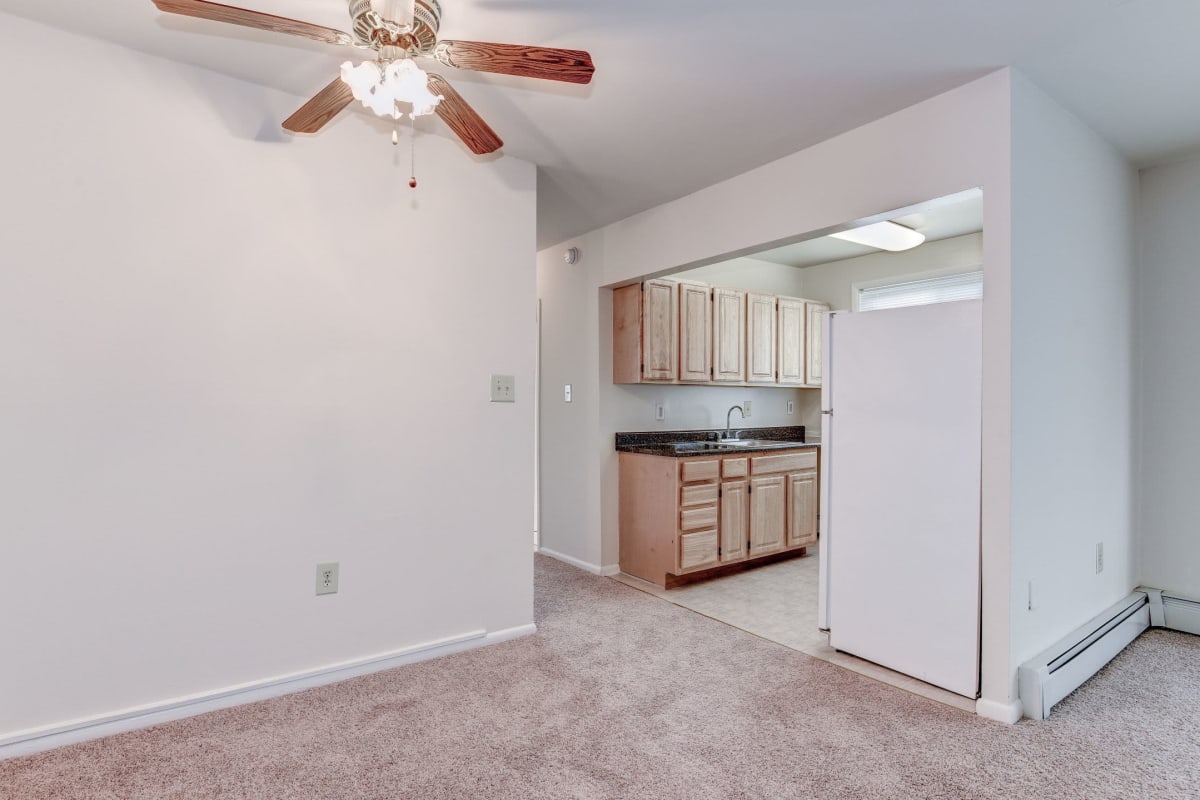 Spacious and carpeted living room leading into the hard floored kitchen at Hawaiian Gardens in Washington, District of Columbia