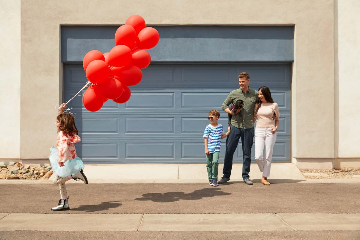 A child holding a bunch of balloons with her family at BB Living Desert Ridge in Phoenix, Arizona
